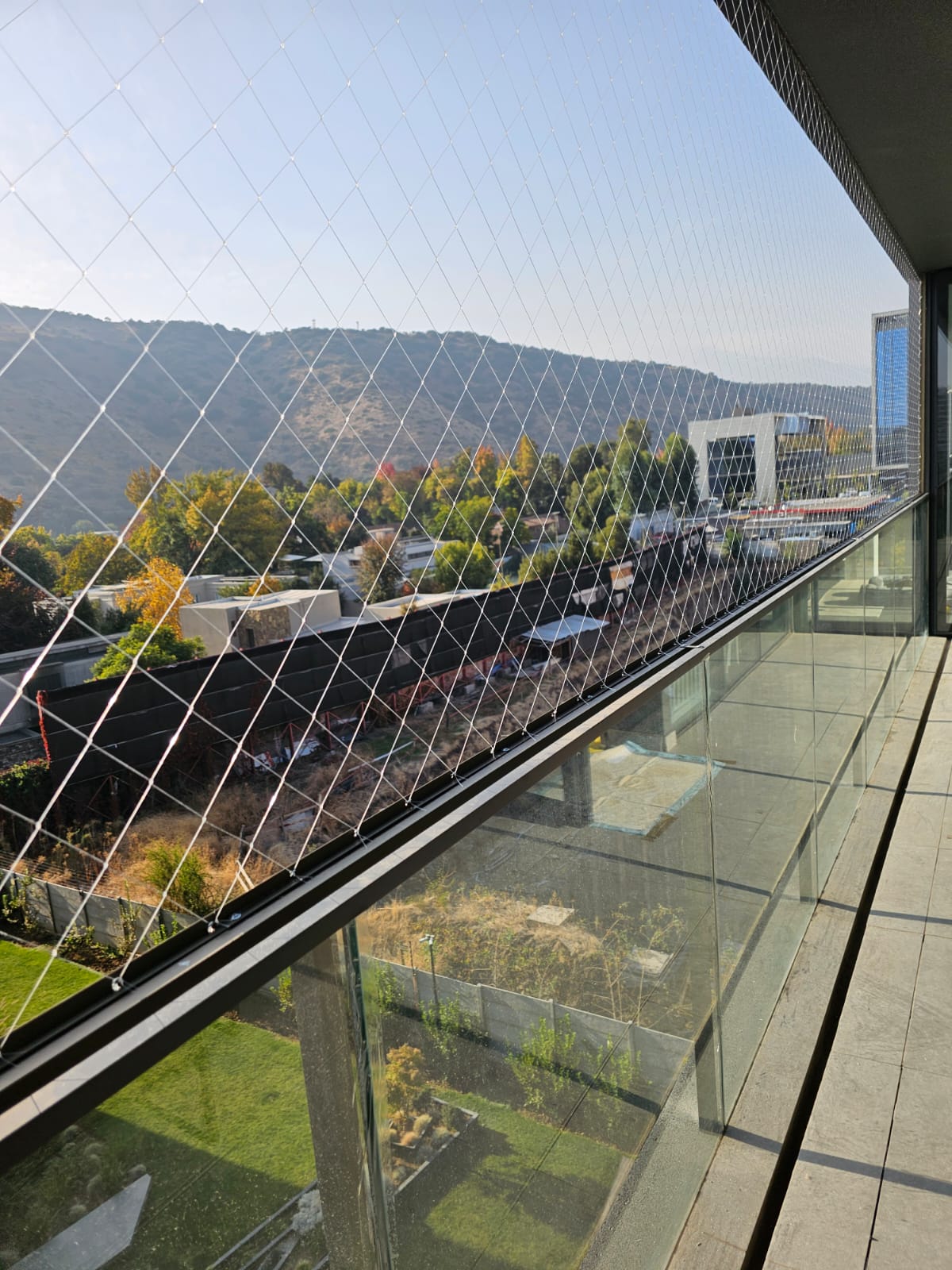 Malla de seguridad instalada en balcón con vista, casi invisible contra el paisaje